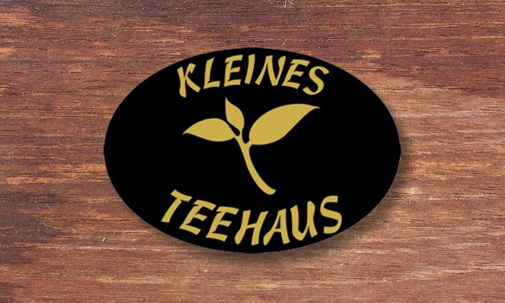 Ovales Logo des Kleinen Teehauses auf Holz