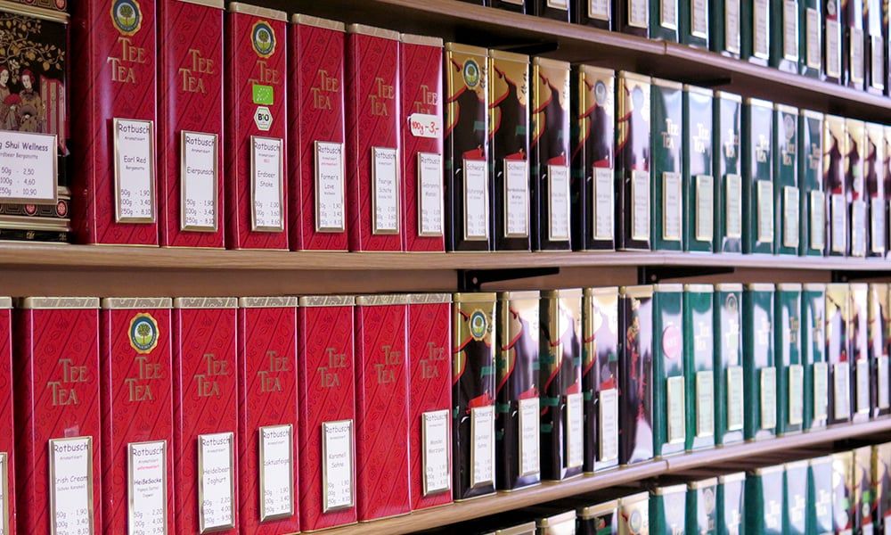 Regal mit roten und grünen Teedosen im Laden