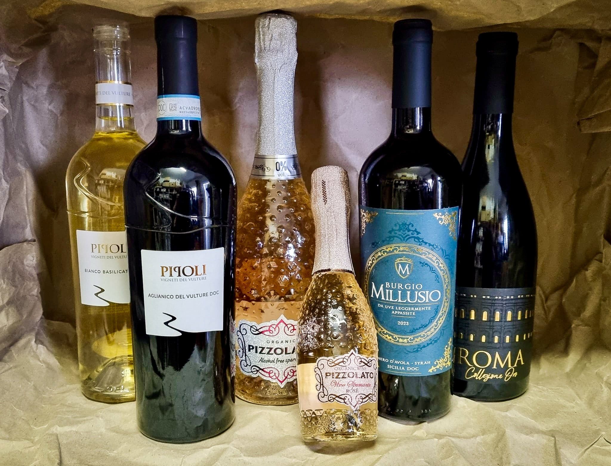 Sechs Wein- und Sektflaschen auf Packpapier