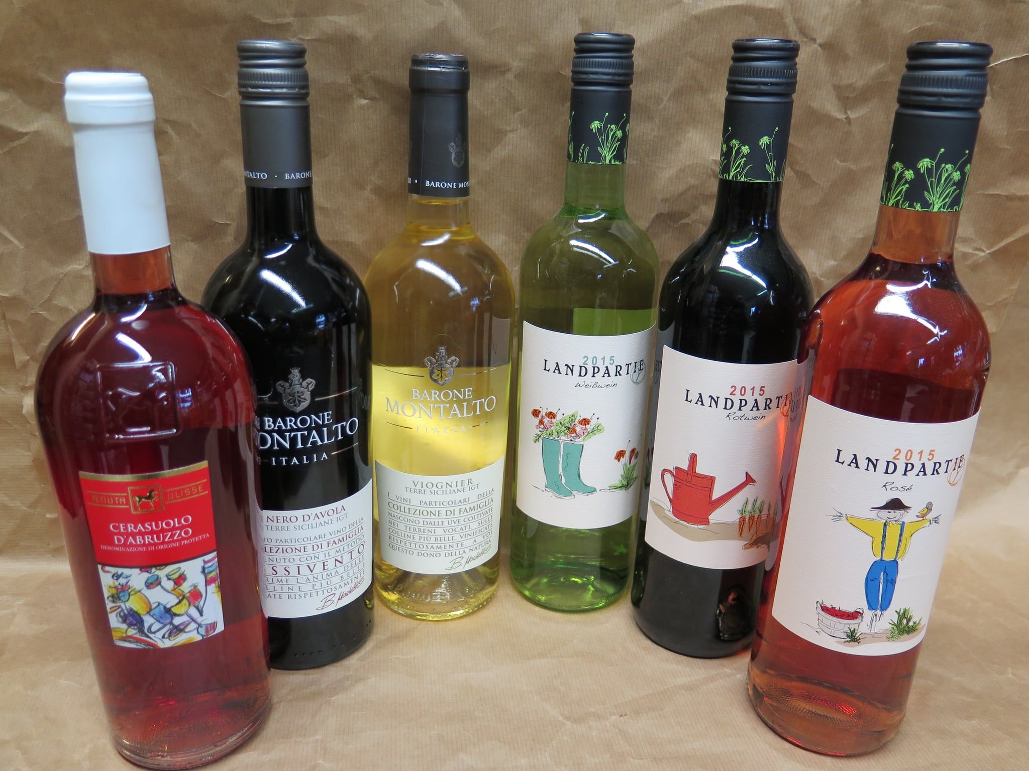 Rot-, Weiß- und Roséweinflaschen auf Packpapier